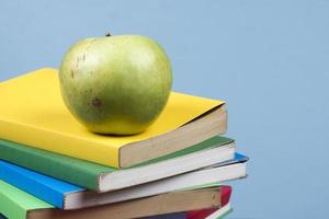 Apple fruit on top of a book stack, on the back of school classes. photo