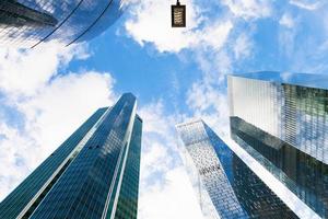 autumn sky with clouds between glass skyscrapers photo