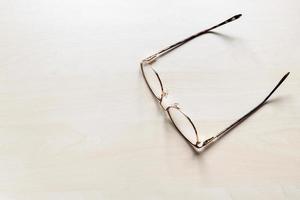 eyeglasses on light brown wooden board photo