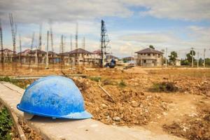 Blue hard hat on house building construction site photo