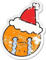 distressed sticker cartoon of a orange wearing santa hat vector