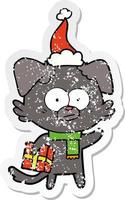 nervous dog distressed sticker cartoon of a with gift wearing santa hat vector