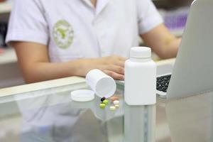 farmacéutico con computadora portátil y medicamentos en la farmacia foto