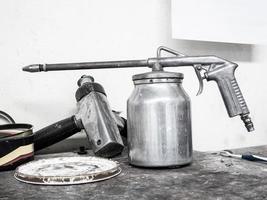 pistola de pintura sobre una mesa de madera en el centro de servicio de reparación de automóviles foto