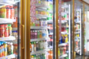 supermarket convenience store refrigerators with soft drink bottles on shelves abstract blur background photo