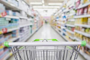 Supermarket aisle with empty shopping cart at grocery store retail business concept photo