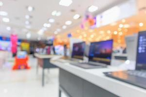 Computer notebook laptop on table at electronics store in shopping mall abstract blur defocused background photo