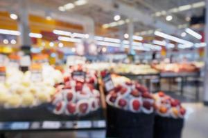 Grocery store with fresh fruits and vegetables shelves in supermarket blur background photo