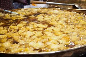 Sopa de fauces de pescado hervido en una sartén grande en el mercado de comida callejera de Tailandia foto