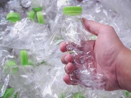 mano de hombre sostenga botellas de plástico, recicle y proteja al mundo del concepto de calentamiento global foto