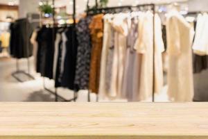 mesa de madera vacía con escaparate de tienda de ropa boutique de moda para mujer en el centro comercial foto