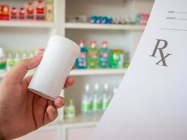 female pharmacist with prescription and medicine at the pharmacy photo