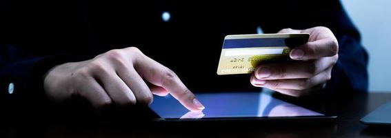 una persona que usa una pantalla táctil con el dedo en la pantalla de la tableta para un negocio de comercio paga en línea con tarjeta de crédito. foto