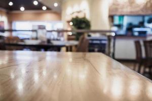 Empty wood table top with blurred cafe restaurant coffee shop interior background photo