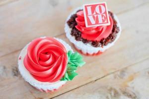 pastelitos de rosas rojas en la mesa de madera foto