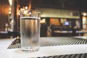 Glass of water on restaurant table photo