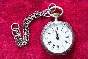 vintage pocket watch with chain on red velvet photo