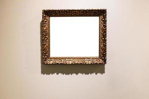 old carved wide bronze picture frame on brown wall