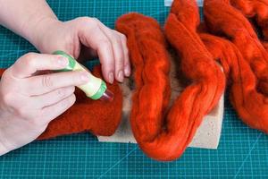 above view of craftsman works with felting punch photo