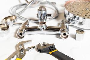 wrenches closeup and disassembled shower faucet photo