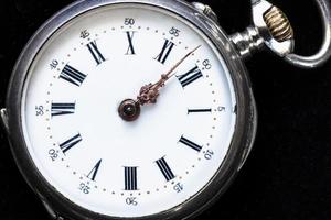 vintage pocket watch on black velvet close up photo