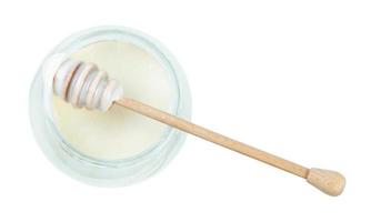 top view of stick over glass jar with white honey photo