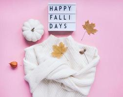 Fall composition with white sweater and pumpkin photo