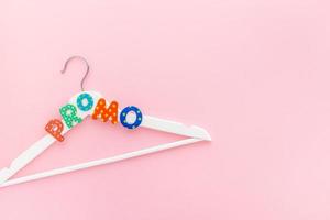 White hangers with promo text on pink background photo