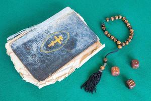 old psalm book, worry beads and three wooden dices photo