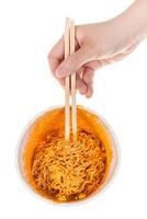 hand keeps chopsticks in prepared instant noodles photo