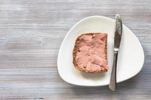 sándwich con paté y cuchillo en plato blanco foto