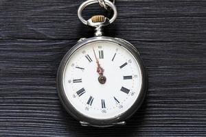 dos minutos para las doce en reloj vintage en negro foto
