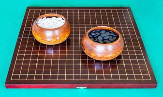 stones for Go game in bowls on wooden board photo