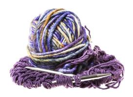 ball of yarn and needles in knitted fabric photo