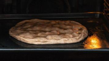 raw closed pie is baking in electric oven photo