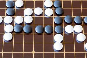 gameplay of Go game on wooden board photo