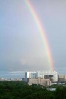 rainbow in blue cloudy sky over high-rise houses photo