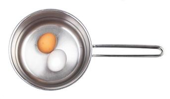 top view of eggs in saucepan with water isolated photo