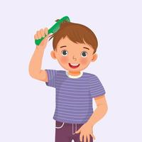 cute little boy holding comb enjoying combing his hair vector