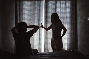 Young couple quarreling in the dark bedroom at home photo