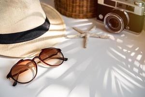 Travel accessories on the table with shadow of plam leave, Summer vacation concept photo