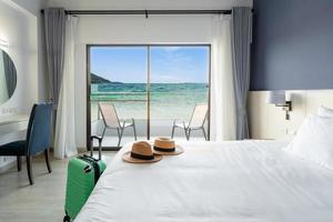 habitación de hotel de lujo con vistas al mar con equipaje, concepto de viaje foto