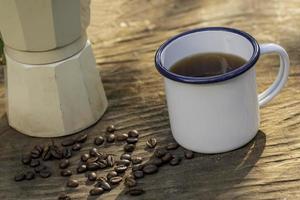 white enamel coffee mug on the old wooden table photo