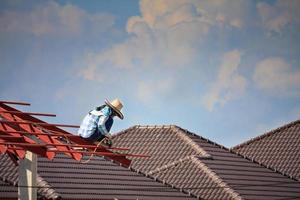 welder workers installing steel frame structure of the house roof at building construction site photo