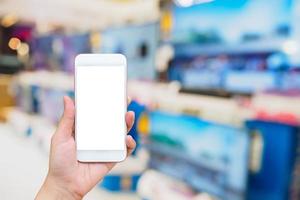 hand hold smartphone with Television shelf in eletronic department store photo