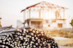 steel rebar for reinforcement concrete at construction site with house under construction background photo