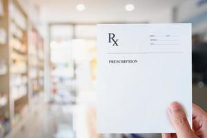 Pharmacist hold blank prescription in pharmacy store photo