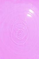 Defocus blurred transparent purple velvet colored clear calm water surface texture with splashes and bubble. Trendy abstract nature background. Water wave in sunlight with copy space. Water texture. photo