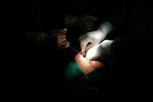 Hand of the medical team performing a surgical operation in the modern operating room. photo