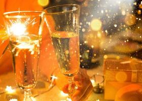 Sparklers in a glass of champagne - transparent glass with wine and splashes. New Year, festive mood, celebration. Christmas photo